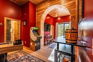 Game room with pool table and arcade in a rustic log cabin rental with hot tub in Gatlinburg
