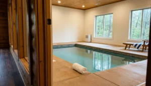 Clean private indoor pool inside a Pigeon Forge TN cabin rental with clear water and folded towels on the pool surround
