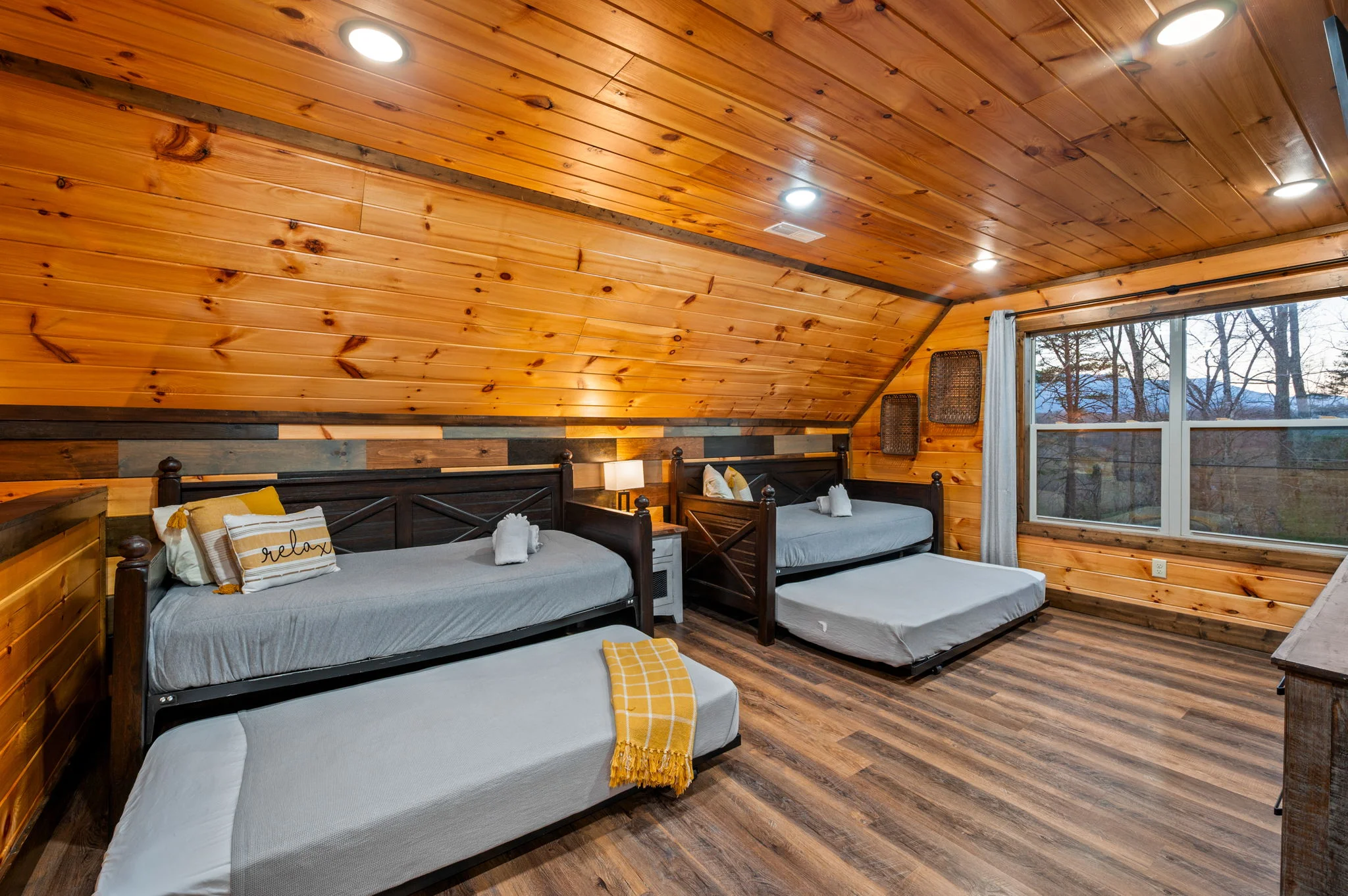 Rustic log cabin bedroom with multiple beds and mountain forest views in Gatlinburg TN