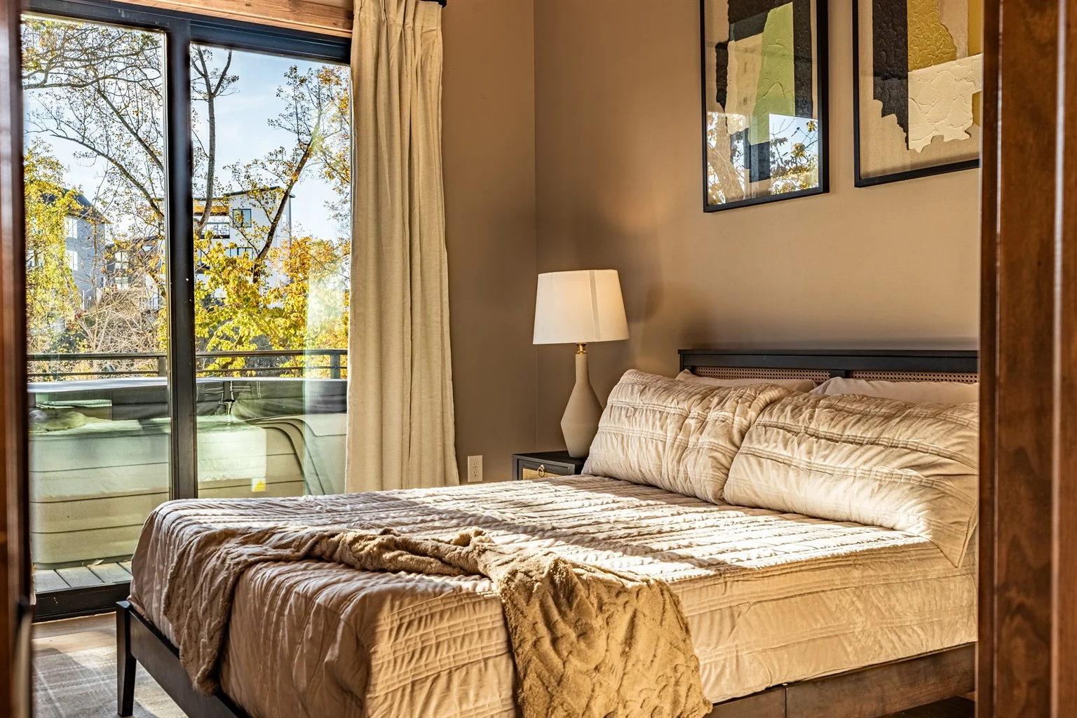 Queen bed with neutral bedding in romantic 1 bedroom cabin in Gatlinburg TN with forest balcony view