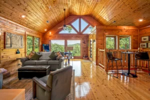 Spacious log cabin living room with cathedral ceiling, skylights, and mountain views in Sevierville vacation rental