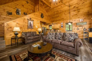 Spacious rustic log cabin living room with leather sofas and wildlife decor in a vacation rental by owner Gatlinburg TN area
