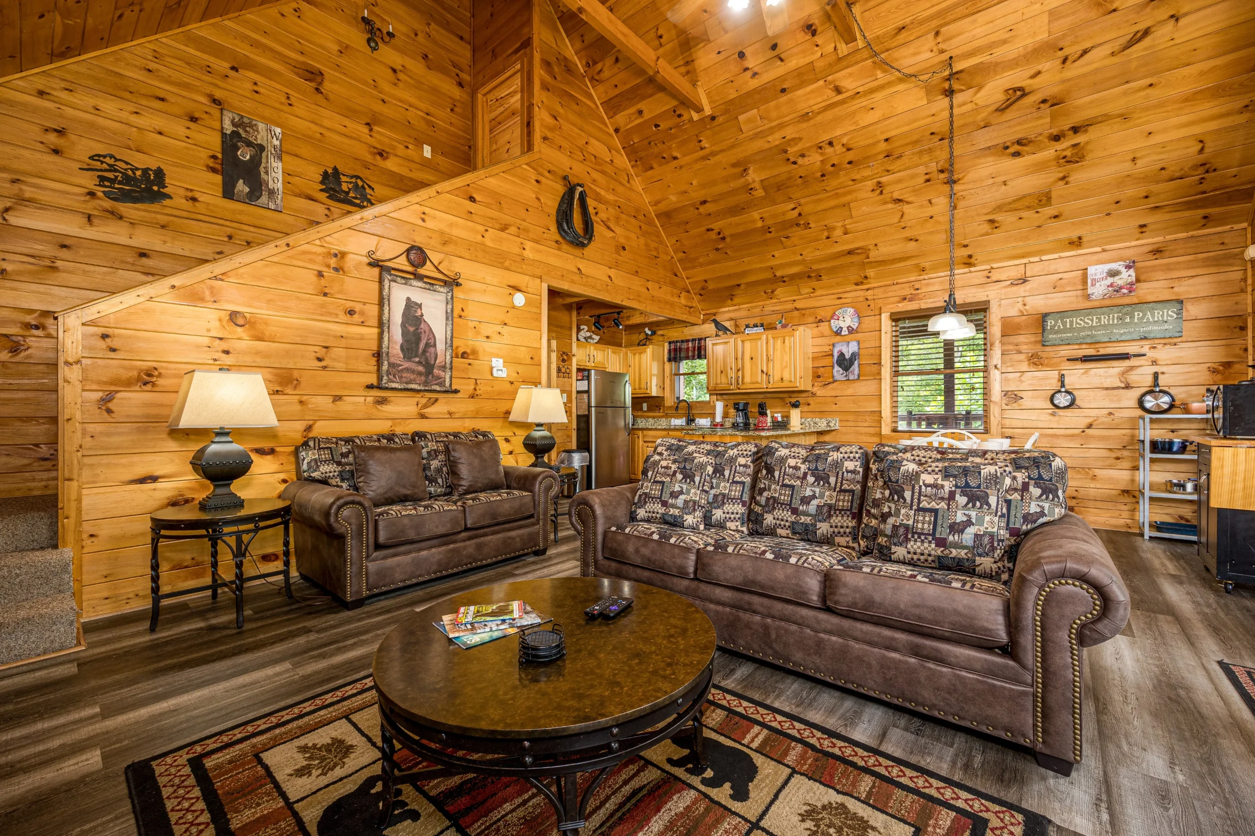 Spacious rustic log cabin living room with leather sofas and wildlife decor in a vacation rental by owner Gatlinburg TN area