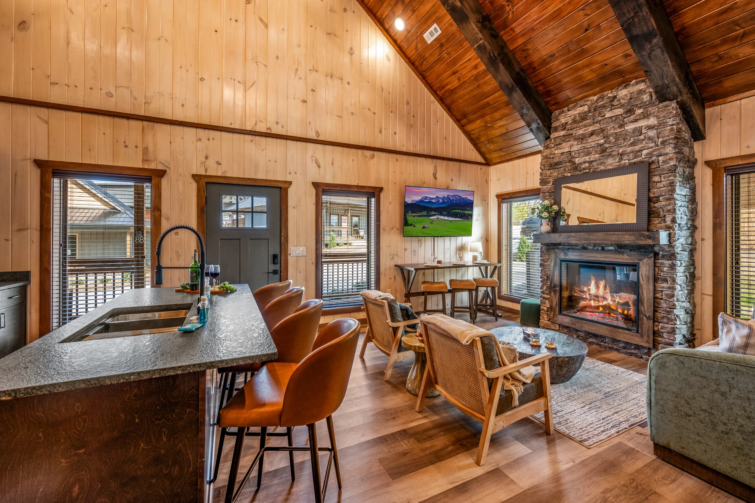 Spacious cabin in the Smokies living room with stone fireplace, exposed wood beams, and mountain views