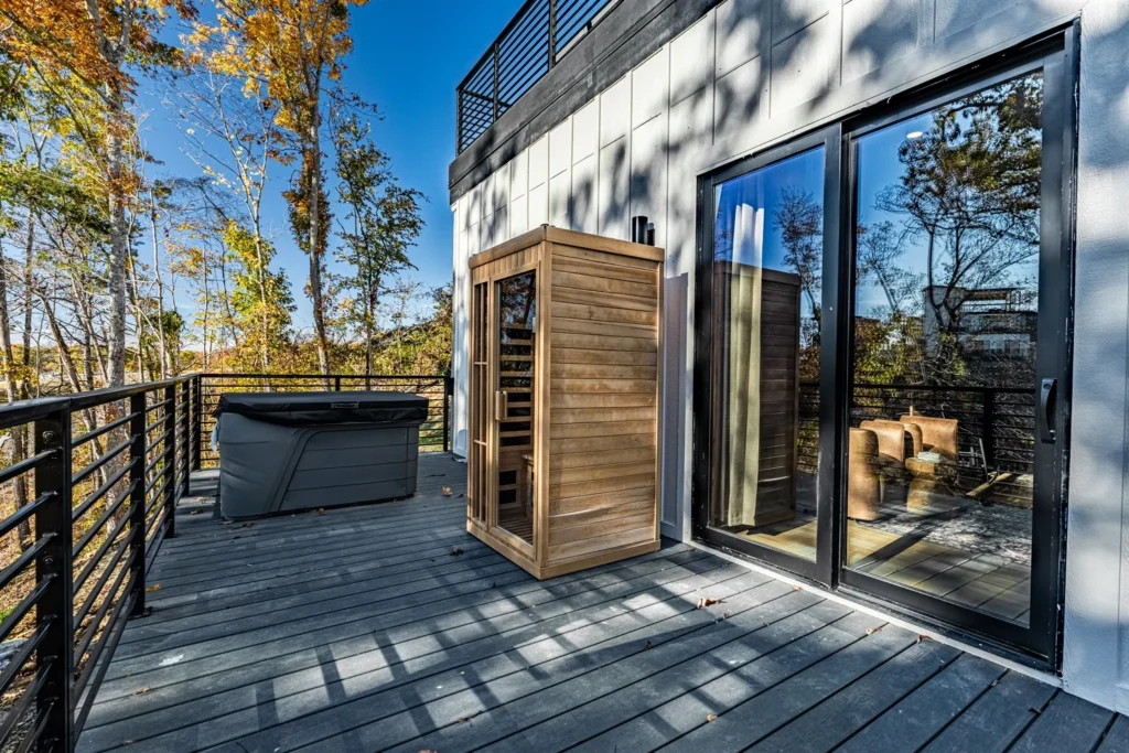 Modern luxury deck with hot tub and sauna overlooking forested mountains in Pigeon Forge cabin rental