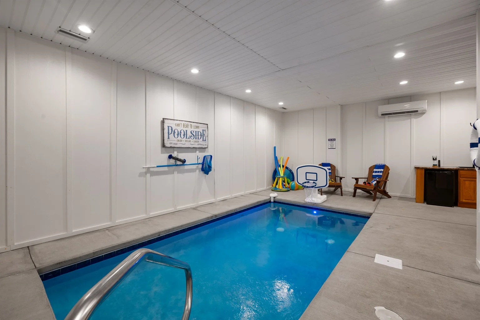 Indoor saltwater pool with lounge chairs and amenities in a Tennessee cabin private pool rental
