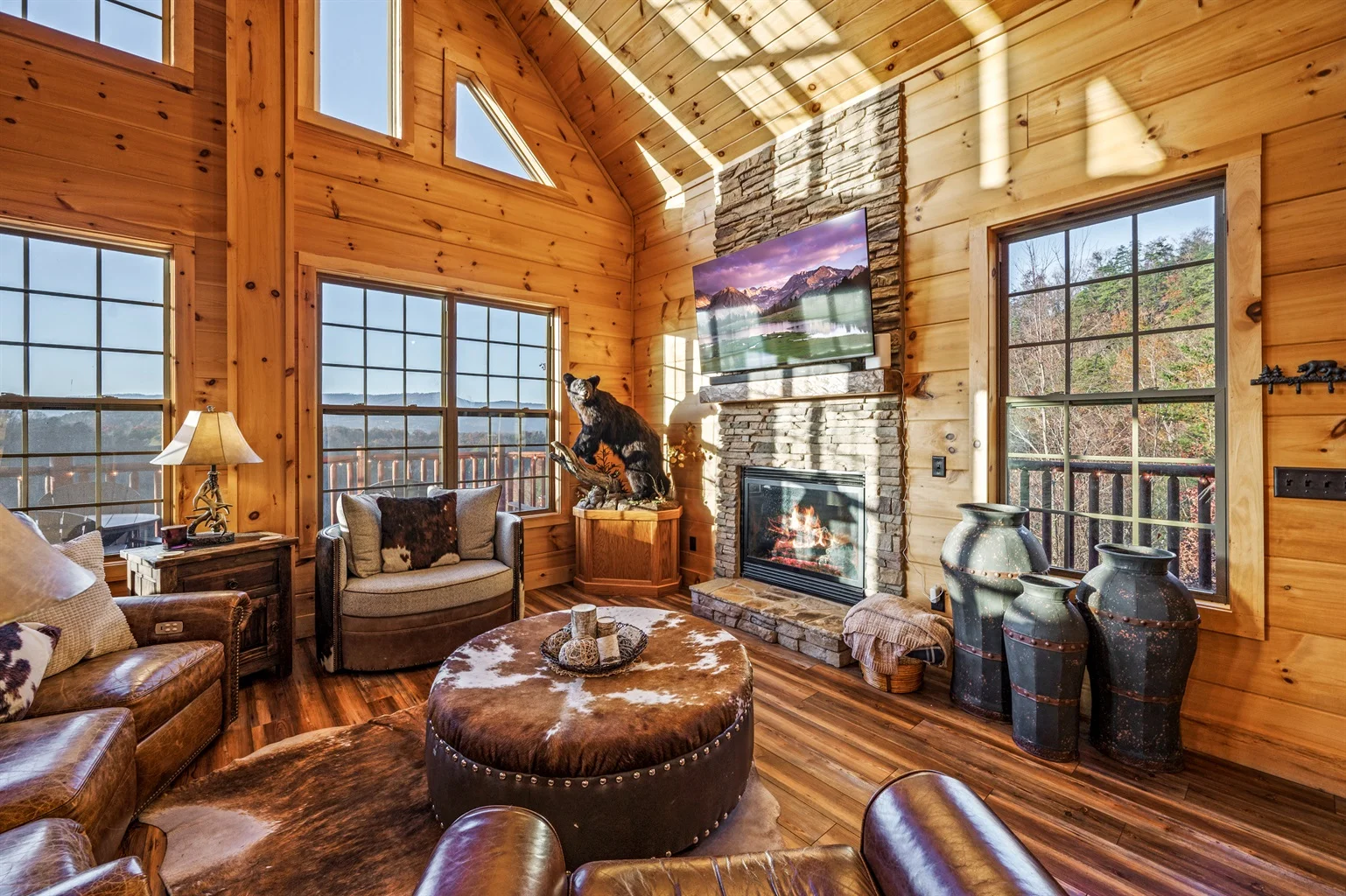 Luxury log cabin living room with stone fireplace and mountain views in Sevierville TN rental