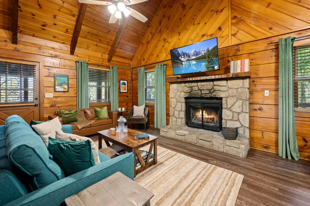 Large group cabin living room with stone fireplace and wood interior in Sevierville