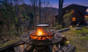 Two-tier fire pit on wooden deck with log cabin in Pigeon Forge forest setting at twilight