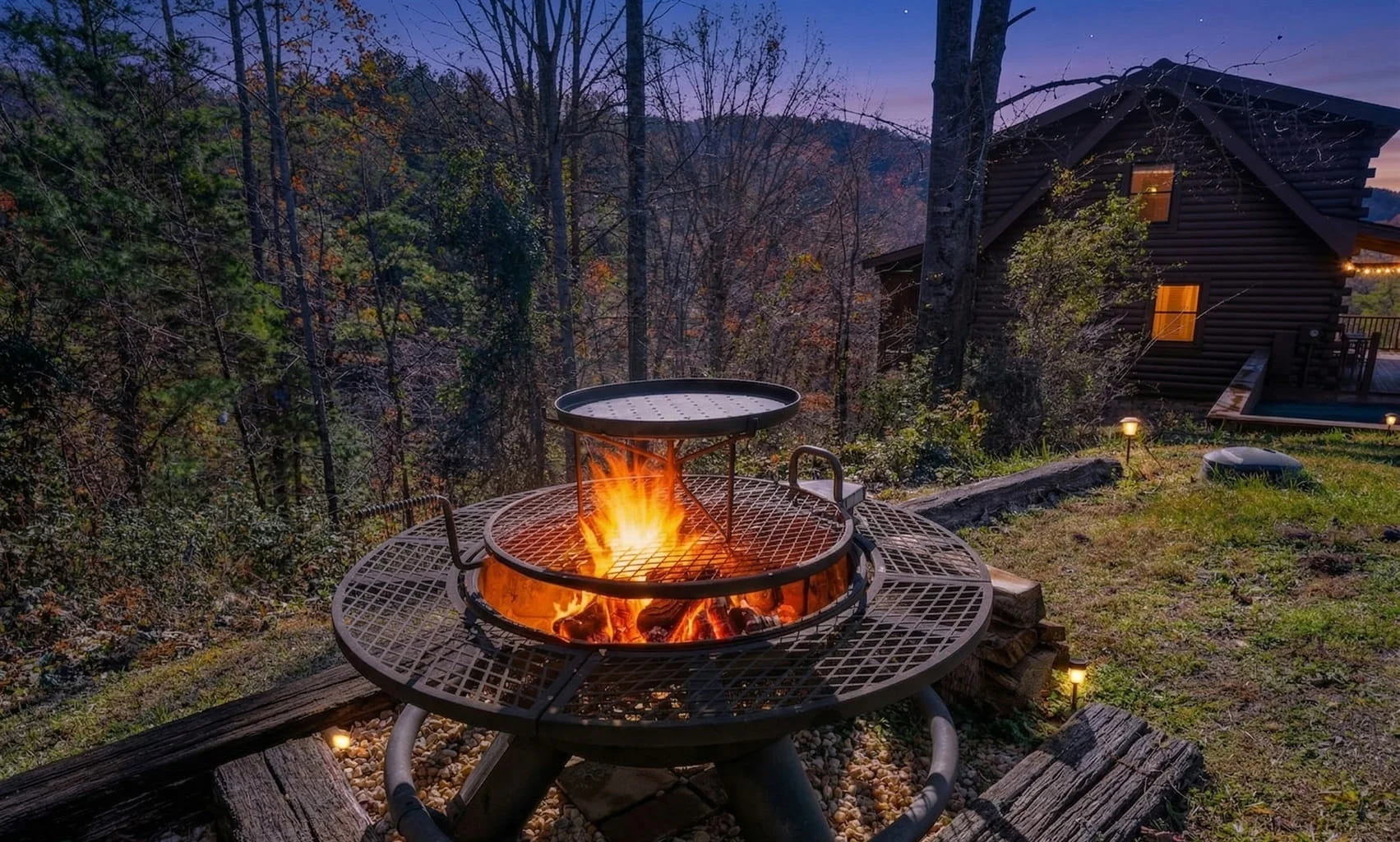 Two-tier fire pit on wooden deck with log cabin in Pigeon Forge forest setting at twilight