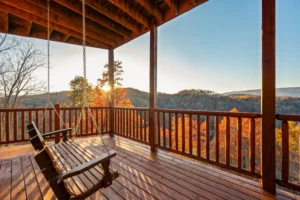 Covered porch with wooden swings overlooking autumn mountain views in a Sevierville vacation rental