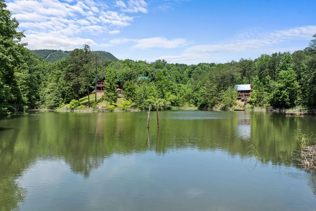 Waterfront cabin rentals in Smoky Mountains with river view, wooden dock, and forested mountainside