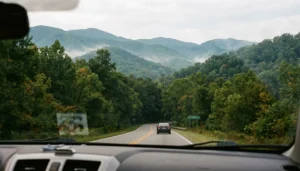 Two-lane road from Pigeon Forge toward Smoky Mountains under overcast sky, showing how far Pigeon Forge is from the Smokies