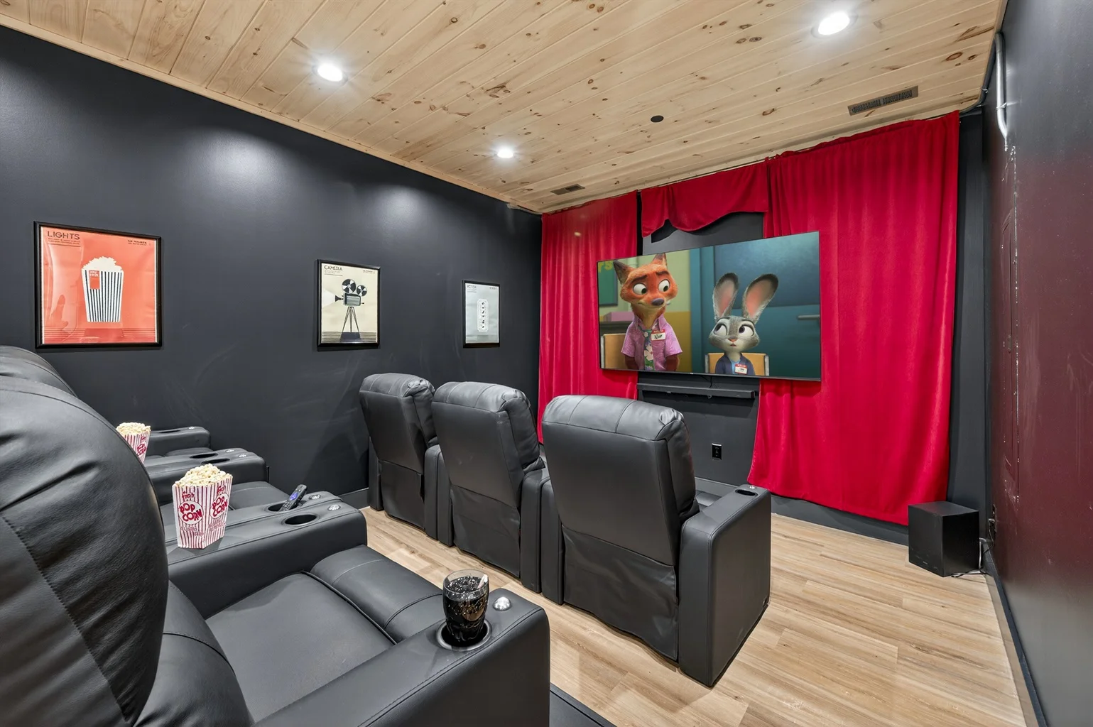 Modern home theater with black recliners and flat-screen TV at Hemlock Hills Cabin Rentals in Sevierville