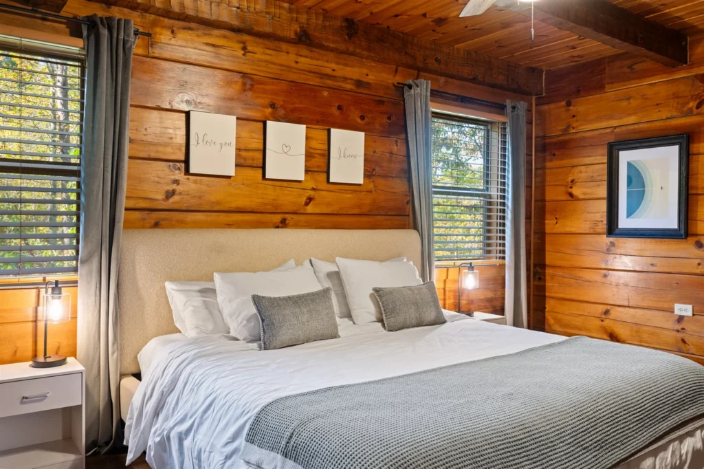 Master bedroom with king bed and rustic log cabin decor offering family reunion group accommodations in Gatlinburg
