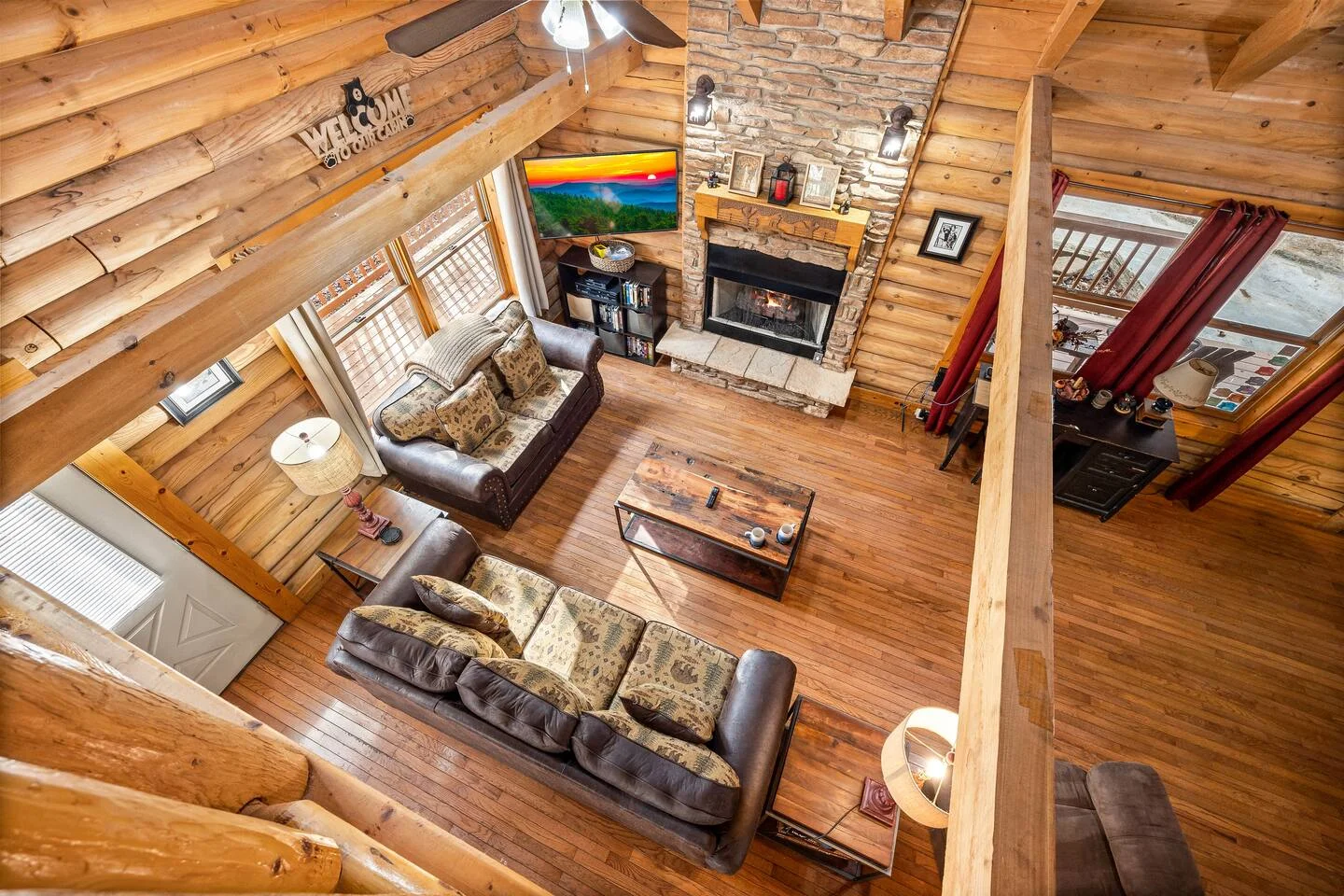 Log cabin living room with stone fireplace, ideal for group vacation packages for family reunions in Gatlinburg