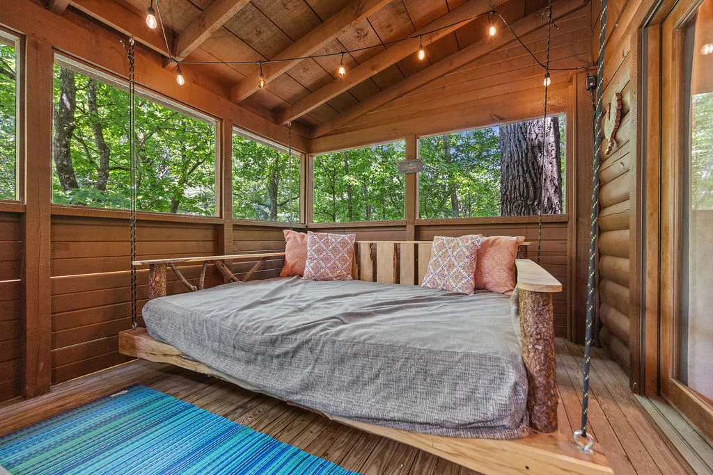 Suspended bed in rustic 4 bedroom cabin bedroom with forest views and pendant lighting in Sevierville