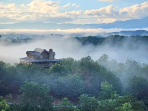 Elevated mountain cabin with stone chimney overlooking misty valley in Sevierville, TN