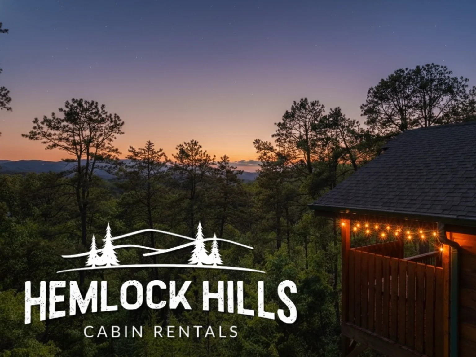 Modern secluded cabin at twilight with glowing deck lights and mountain sunset views in Sevierville Tennessee