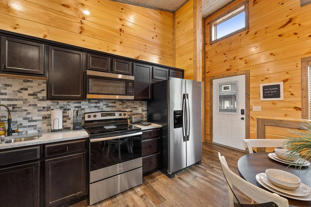 Modern log cabin kitchen with stainless steel appliances in cheap cabins in Gatlinburg