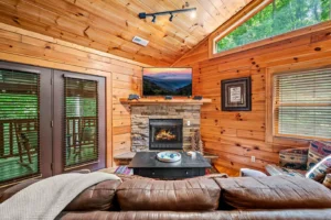 Cozy cabin rental living room with stone fireplace and leather sectional in Gatlinburg