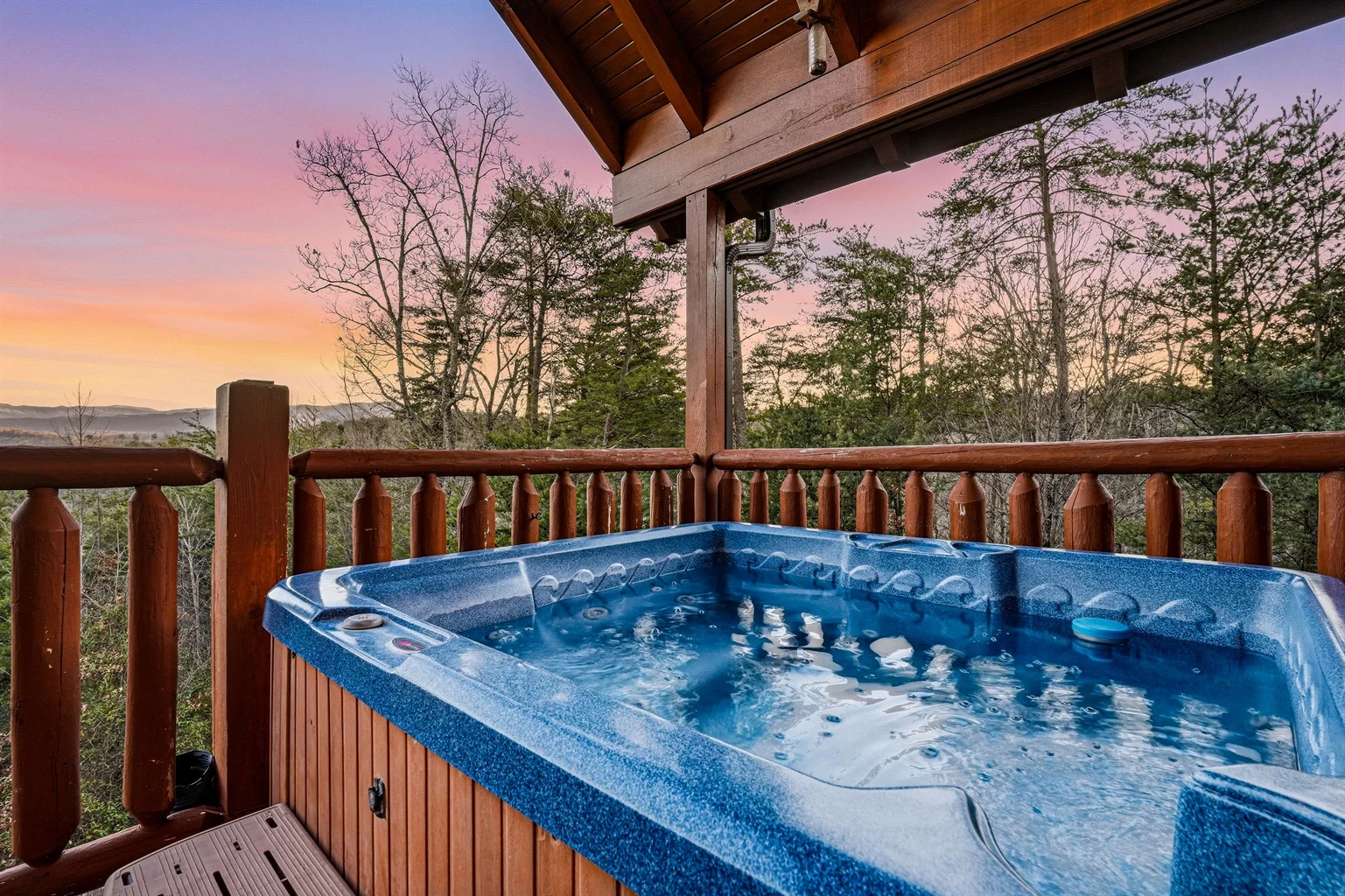 Mountain view hot tub on wooden deck at sunset in vacation rental in Great Smoky Mountains