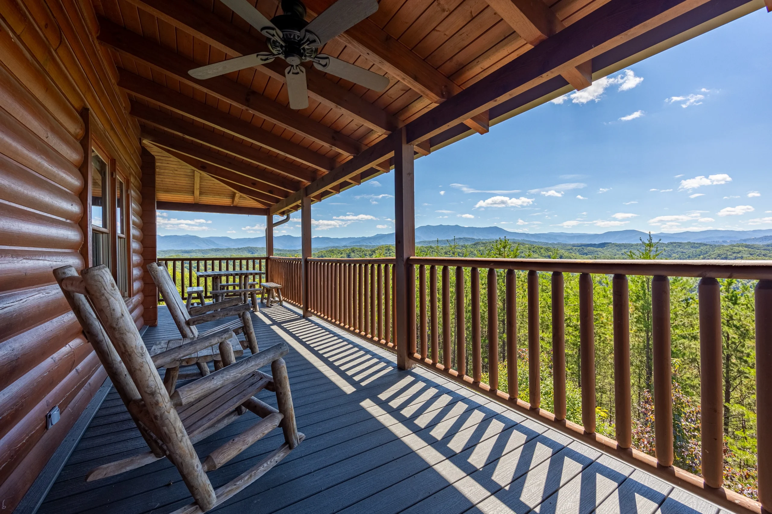 Covered deck with Adirondack chairs overlooking scenic mountain vistas in Sevierville
