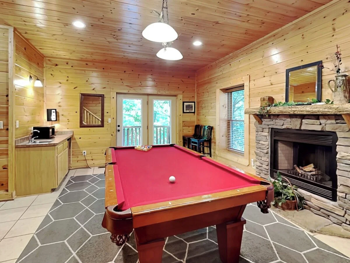 Log cabin game room with pool table, fireplace, and forest views near Pigeon Forge
