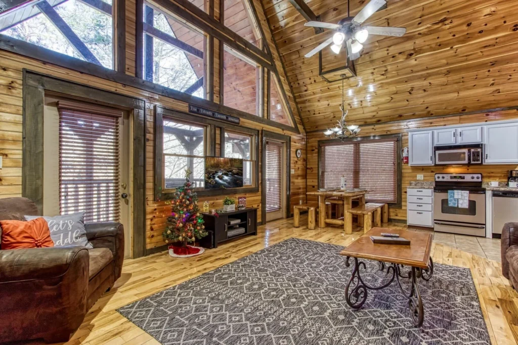 Spacious log cabin interior with open living room, kitchen, and holiday decor for advance Gatlinburg booking