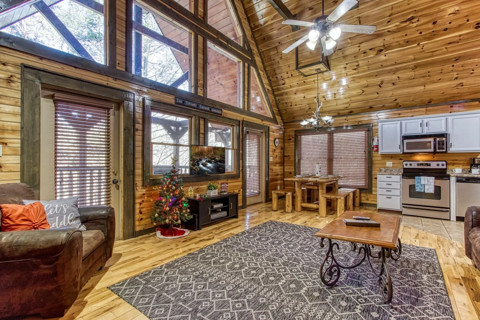 Spacious log cabin interior with open living room, kitchen, and holiday decor for advance Gatlinburg booking