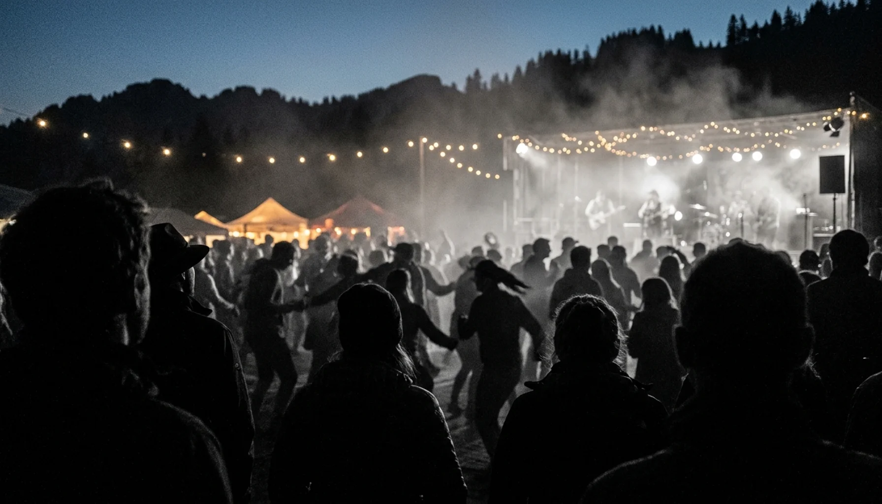 Crowd silhouettes at Oktoberfest at Ober Mountain Gatlinburg with stage haze and mountain lights