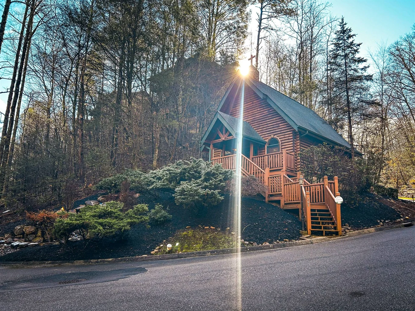 Log cabin with peaked roof and wooden porch in forest setting, perfect bachelorette party cabin in Gatlinburg